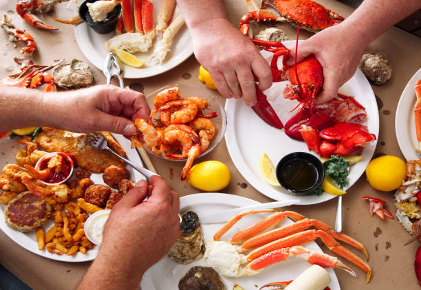 Overhead view of two men eating at a seafood feast